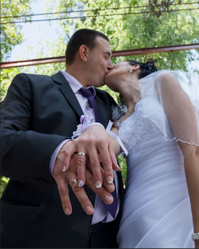 близък кадър на младоженци с халки на ръце от сватбена им фотосесия